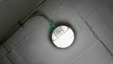 Round shaped ceiling lamp in basement on concrete background Stock Footage 102037972