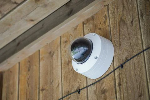 Round shaped weathersealed Security camera on the wooden wall Stock Photos