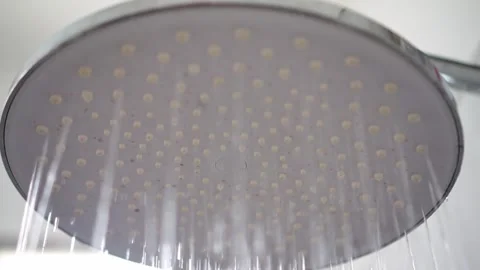 Round shower head is turning on with running water, bathroom fixture spraying Stock Footage 342634936