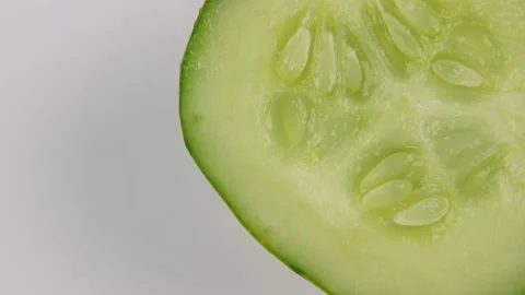 Round slice of cucumber rotating on white background Stock Footage 138894911