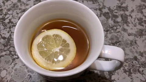Round slice of lemon in a mug of hot tea Stock Footage 125509997