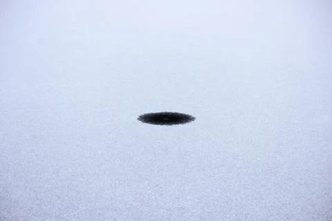 Round small hole in thin ice on a lake in the park Foto stock gratuite