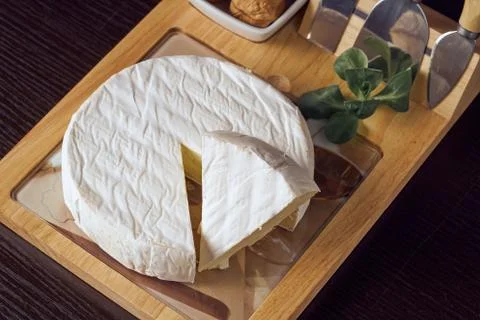Round soft cheese, with a section cut. Stock Photos