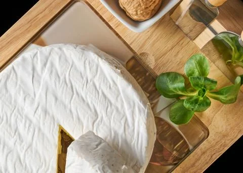 Round soft cheese, with a section cut. Stock Photos