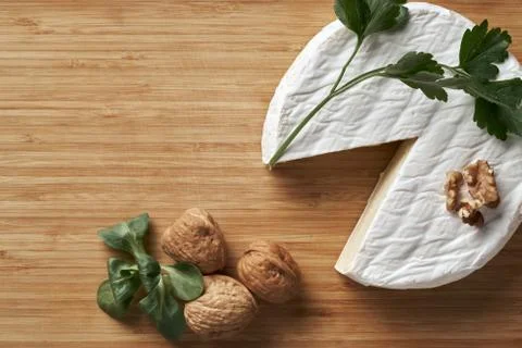 Round soft cheese, with a section cut. Stock Photos