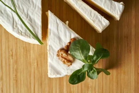 Round soft cheese, with a section cut. Stock Photos