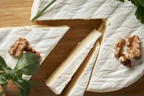 Round soft cheese, with a section cut. Stock Photos