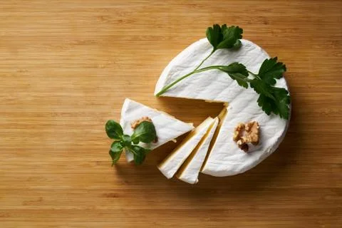 Round soft cheese, with a section cut. Stock Photos