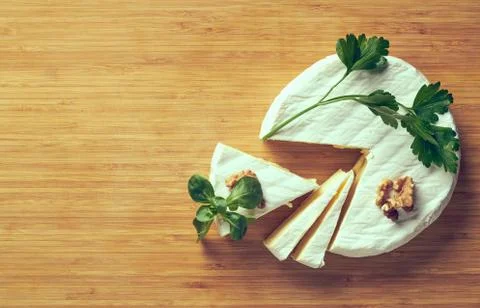 Round soft cheese, with a section cut. Stock Photos