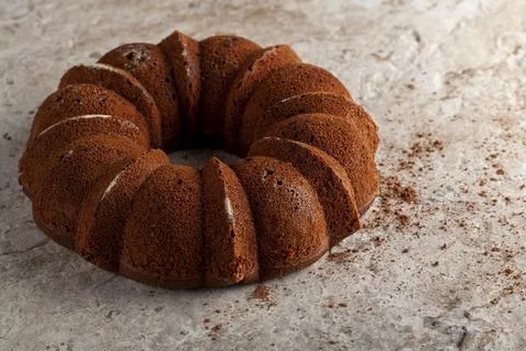 A round sponge cake fresh out of oven with crumbles and cacao powders cooling Stock Photos