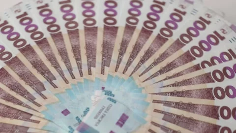 Round stack fan of one thousand hryvnia bills rotates fast on white background Video stock 324758757