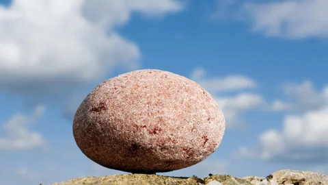 Round stone on a blue cloudy sky background Video stock 152384386