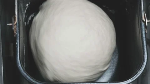 Round stone of white wheat dough is kneaded in metal form of electric bread Stock-Footage 196268916