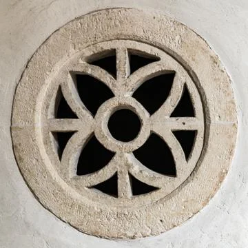 Round stone window within a symmetrical design. Stock Photos