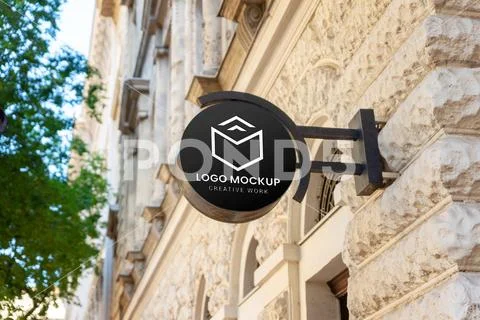 Round street sign logo mockup on modern building in city center close up Plantilla PSD