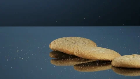 Round sugar cookies falling on blue reflective studio surface Stock Footage 327577408