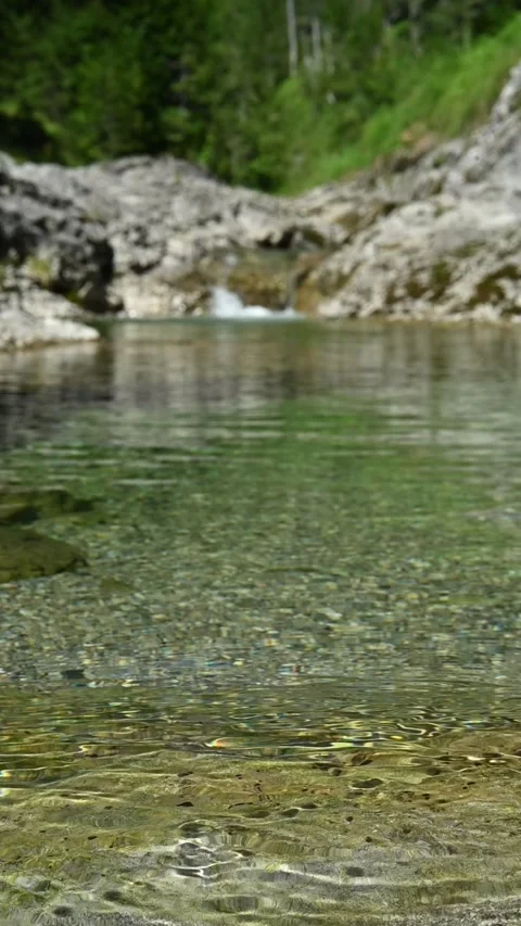 Round sunlight effects on the ground of a mountain stream in summer, vertical Stock-Footage 260879089