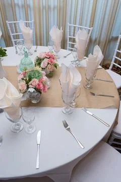 Round table is adorned with a vibrant display of fresh pink roses and white flow Stock Photos