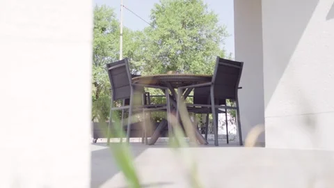 Round Table and Chairs on Sunny Terrace, Modern Building Exterior, Static Shot Vídeos de archivo 341571942