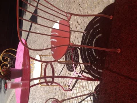 Round table with pattern and chair of caffee shop throw shadows to cobblestones Stockfoto's
