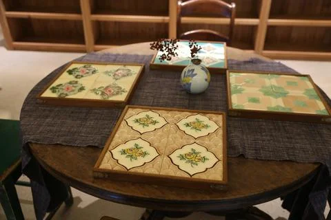 On the round table, there is an empty square wooden frame with four tiles o.. Stock Photos