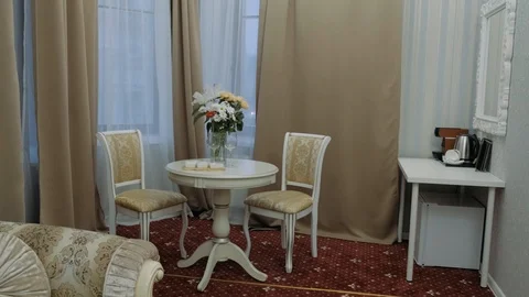 On a round table in a vase are real fresh flowers are two glasses. Stock Footage 123588839