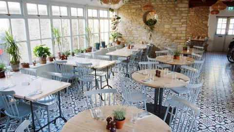 Round tables and duck-egg blue chairs in an empty restaurant with patterned Stock Footage 99752326