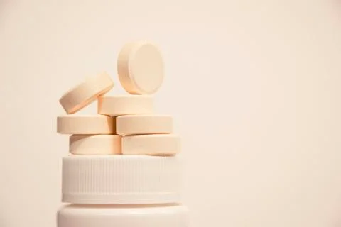 Round tablets are placed on a jar. Medicine and health. Stock Photos