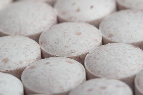 Round tablets with subtle speckles lie close together Stock Photos