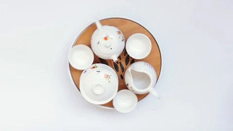 Round tea table with utensils in turn on white background Stock Footage 113199282