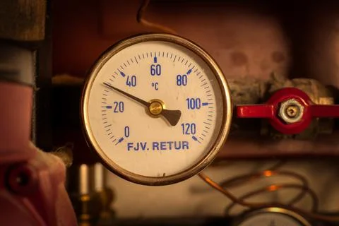 A round temperature meter on the returning water to a district heating syste Stock Photos