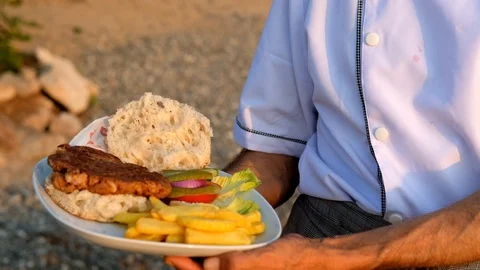 Round view footage of a cheff holding a shrimpburger near seaside Stock Footage 111494075