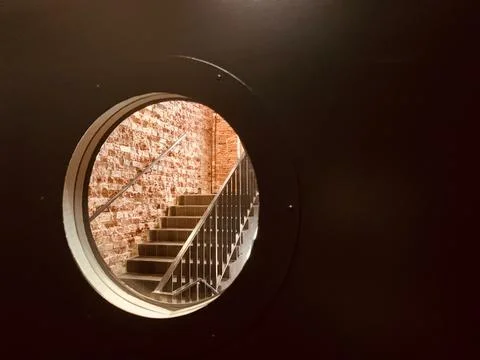 Round viewing window in the door. A window in a prison cell. Stock Photos