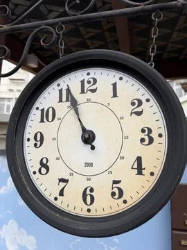 Round wall clock with black frame displaying time at 10:10, mounted on a de.. Stock Photos