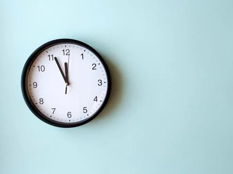 Round wall clock on blue surface showing 12 o'clock, layout, top view Stock Photos