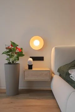 Round wall lamp and bedside nightstand Stock Photos