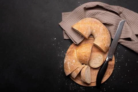 Round wheat bread cut into pieces on a towel Stock Photos