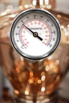 Round white arrow thermometer close-up on a copper tank distiller Stock Photos