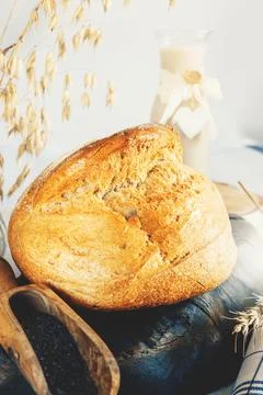 Round white bread. Close-up of white bread with homemade black salt in a wooden Stock Photos