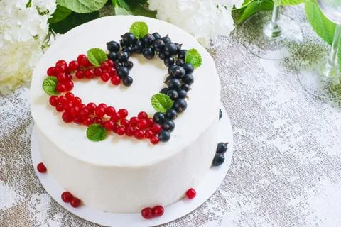 Round white cake with berries in the form of hearts, Valentine's Day, on whit Stock Photos