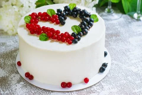 Round white cake with berries in the form of hearts, Valentine's Day, on whit Stock Photos