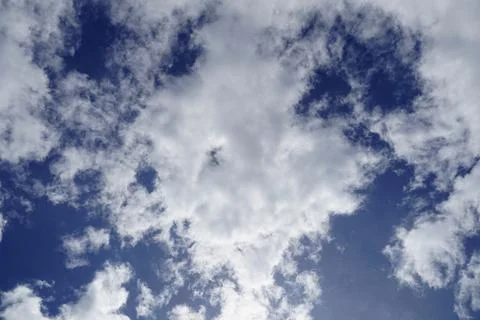 Round white cumulus cloud with a small hole in the middle in a blue sky Stock Photos
