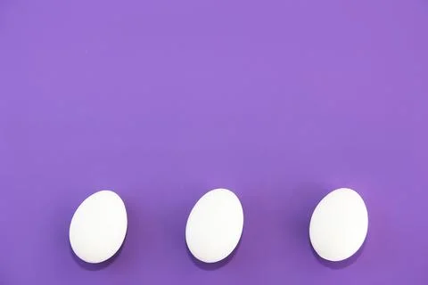 Round white Easter eggs on purple background Stock Photos