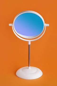 Round white mirror with blue reflection on red Stock Photos