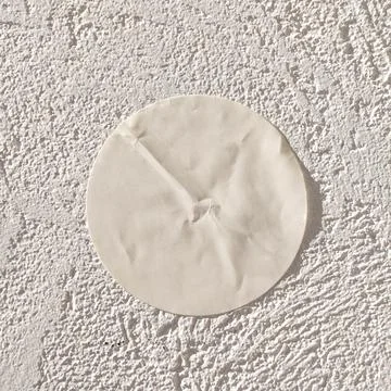 Round white patch on textured wall surface in bright sunlight Stock Photos