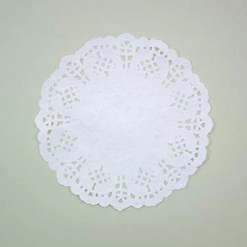 A round white pattern paper on green background Stock Photos