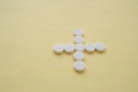 Round white tablets in shape of cross Stock Photos