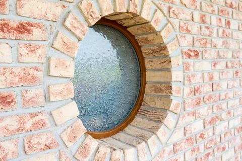 Round window on brick wall - shallow depth of field - focus on the closer a.. Fotos Stock