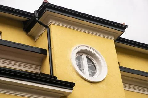Round window on yellow facade Foto stock
