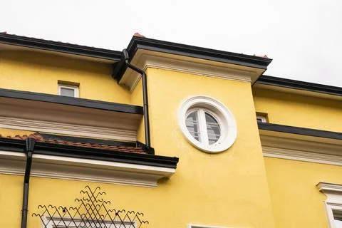 Round window on yellow facade Foto stock